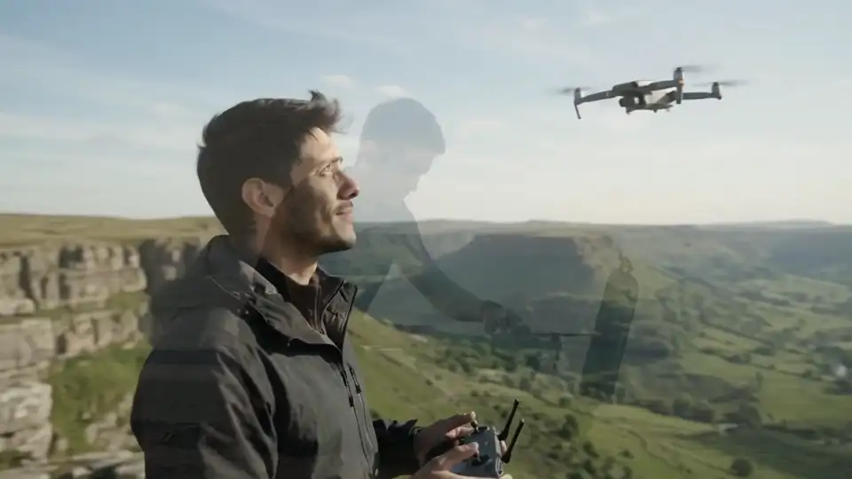 Marcheur dans une prairie dorée filmé au drone